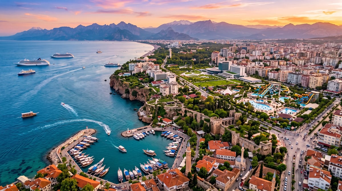 Aerial view of Antalya, Turkey at sunset with the old harbor, Yivli Minare, historic Kaleiçi fortress, marina, and Taurus Mountains in the background