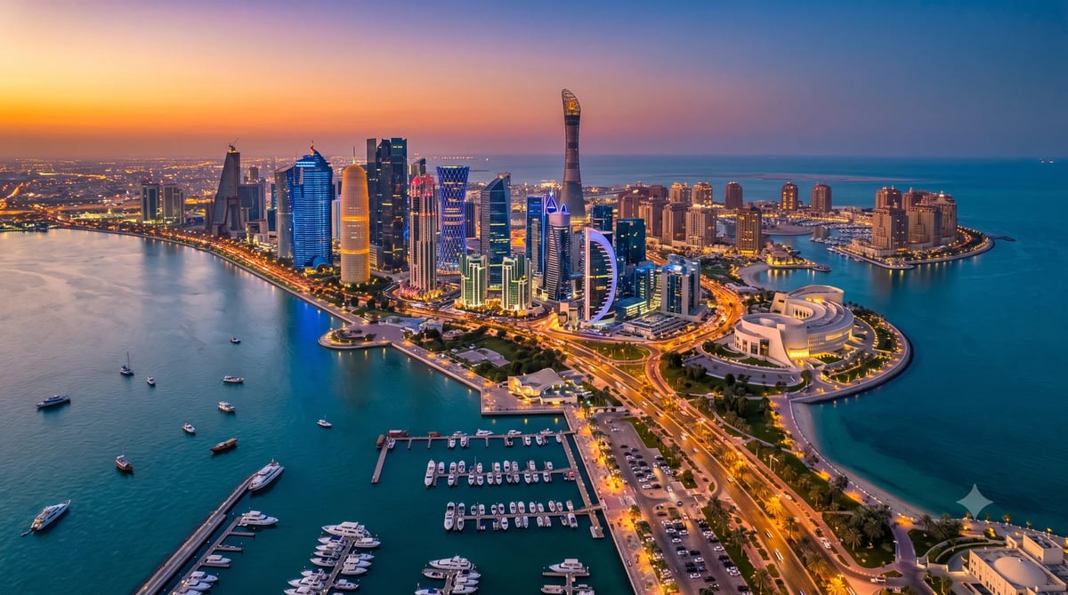 Aerial sunset view of Doha West Bay skyline with illuminated high-rise buildings, marina, and turquoise waters at dusk