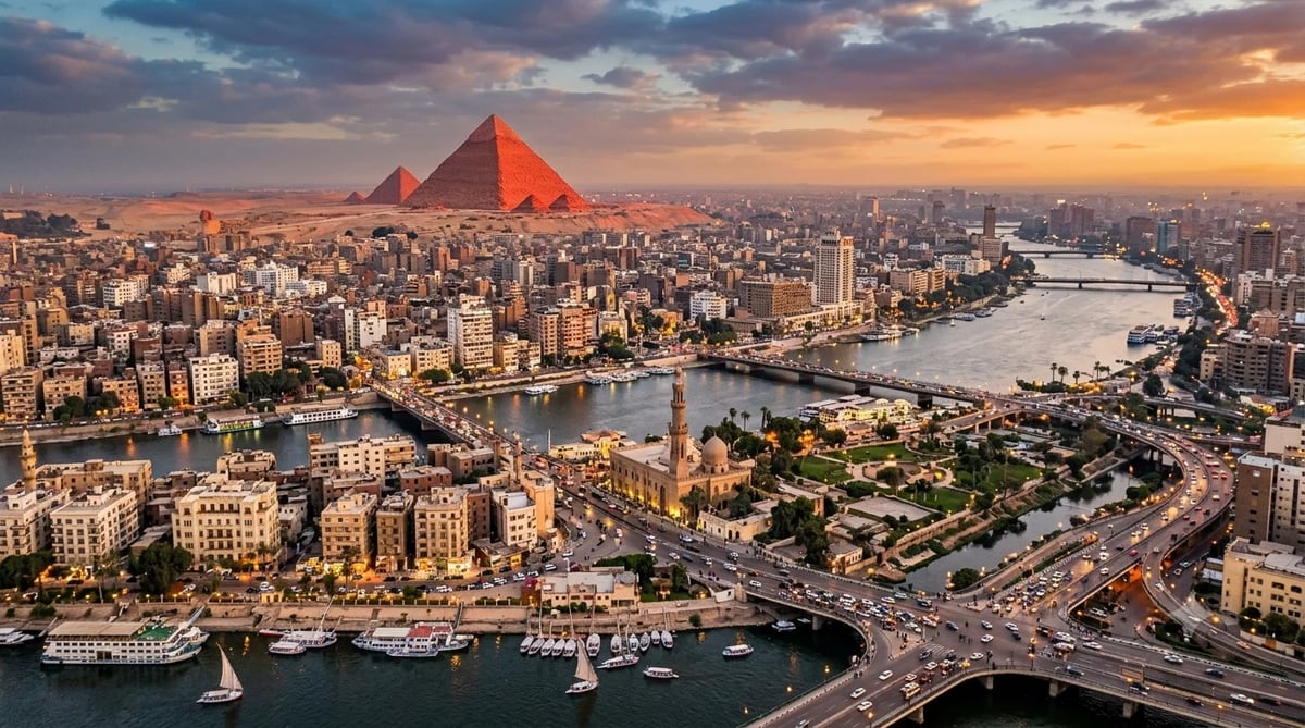 Aerial sunset view of Cairo cityscape with the Great Pyramid of Giza, Nile River, and dense urban architecture lit by golden hour light